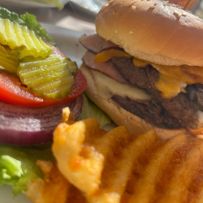 Cheeseburger with fresh toppings and waffle fries at JC's Country Diner Restaurant Elwood Utah.