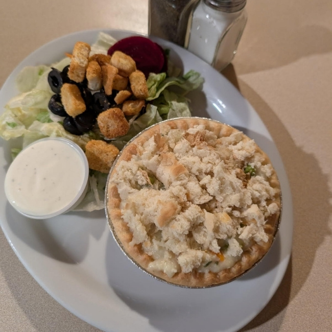 Plate with a salad, ranch dressing, and a mini pot pie at JC's Country Diner Restaurant Elwood Utah.