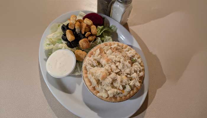 Chicken pot pie and salad from JC's Country Diner Restaurant Elwood Utah, served on one plate.