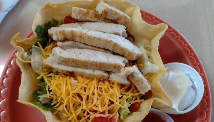 A taco salad bowl from JC's Country Diner Restaurant Elwood Utah with chicken, cheese, and more.