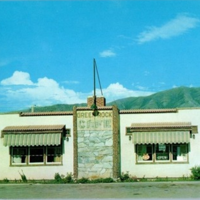 JC's Country Diner Restaurant in Elwood, Utah—a small white cafe with striped awnings and mountains.