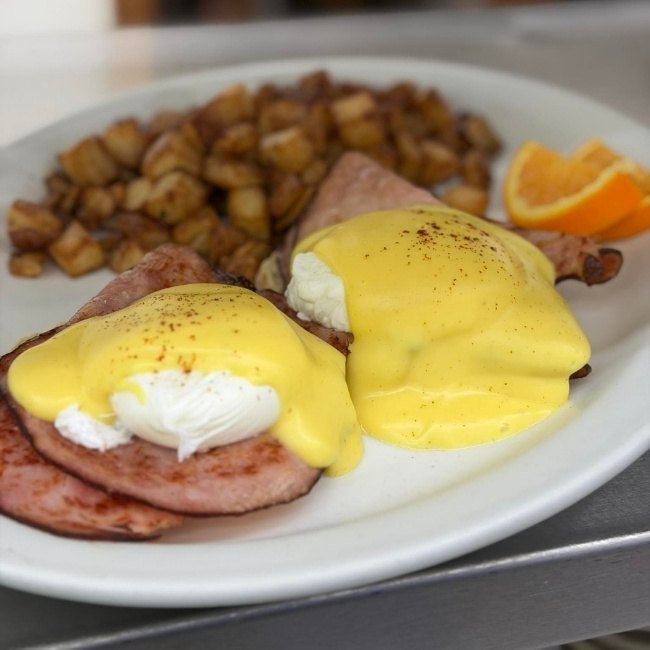 Eggs Benedict with ham, hollandaise, and home fries at JC's Country Diner Restaurant Elwood Utah.