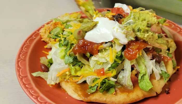 JC's Country Diner Restaurant Elwood Utah serves sopaipilla topped with lettuce, cheese, and salsa.