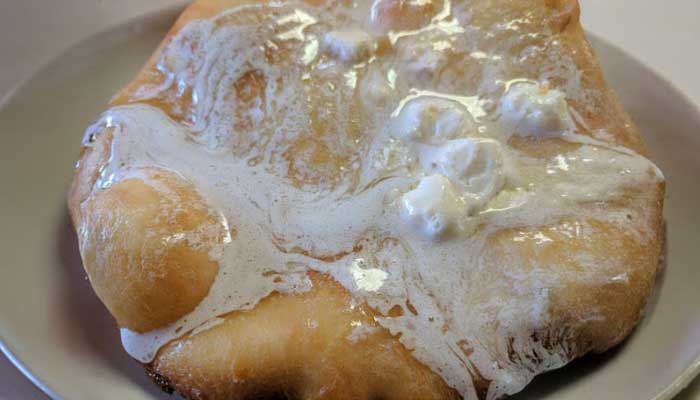 A piece of fry bread with melted white icing at JC's Country Diner Restaurant Elwood Utah.