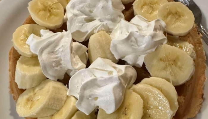 A waffle at JC's Country Diner Restaurant Elwood Utah, topped with bananas and whipped cream.