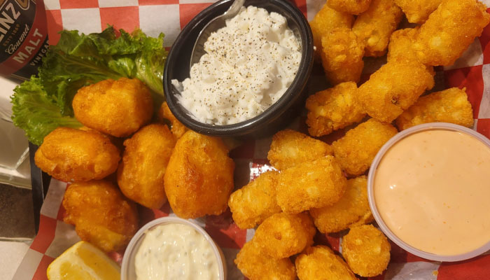 Lunch and Dinner Elwood Utah: Golden fried cheese curds and tots with lettuce, sauces, lemon wedge.